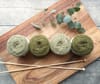 four green yarns on chopping board