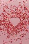 paper hearts scattered on pink background